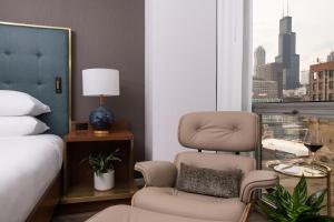 a bedroom with a bed and a chair and a window at Le Meridien Essex Chicago in Chicago