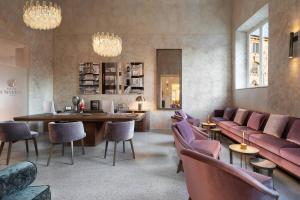 a lobby with pink furniture and a table and chairs at Grand Universe Lucca, Autograph Collection in Lucca