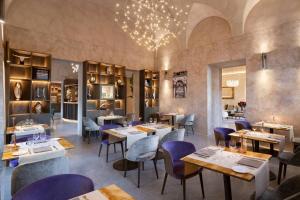 a restaurant with tables and chairs and a chandelier at Grand Universe Lucca, Autograph Collection in Lucca