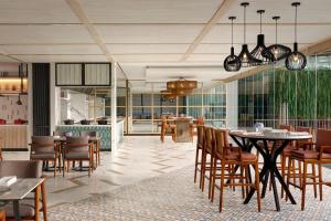 a restaurant with tables and chairs and a dining room at Sheraton Bali Kuta Resort in Kuta