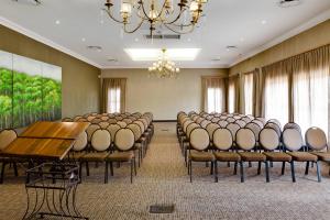 una sala conferenze con sedie, tavolo e lampadario a braccio di Protea Hotel by Marriott Bloemfontein Willow Lake a Bloemfontein