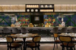 a restaurant with tables and chairs in front of a counter at The Ritz-Carlton, Kuala Lumpur in Kuala Lumpur