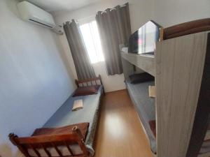 カンポス・ドス・ゴイタカゼスにあるGaia Campos Trevoのソファ、デスク、テレビが備わる小さな客室です。