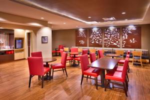 una sala da pranzo con tavoli e sedie rosse di TownePlace Suites by Marriott Dickinson a Dickinson