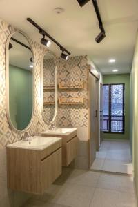 a bathroom with two sinks and two mirrors at Ventiuna Hotel y Coliving in Pereira