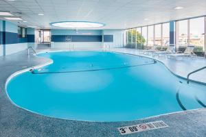 a large swimming pool in a building with blue water at Four Points by Sheraton Milwaukee Airport in Milwaukee