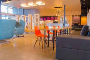 a restaurant with chairs and a table and a counter at Aloft Corpus Christi in Corpus Christi
