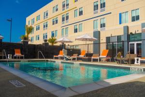 a swimming pool in front of a building at Aloft Corpus Christi in Corpus Christi