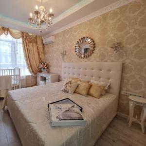 a bedroom with a large bed with a mirror on the wall at Luxury Apartment on Krymskaya 22 in Gelendzhik