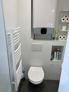 uma casa de banho com um WC branco e um armário branco em Deux pièces familial chic et confortable - Square Courteline - Nation - Paris centre em Paris