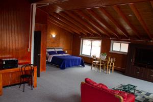 a bedroom with a bed and a table and chairs at Hotel Gran Luna in Puerto Montt