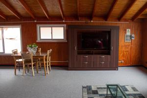 una sala da pranzo con tavolo e TV a schermo piatto di Hotel Gran Luna a Puerto Montt