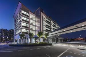 un edificio de oficinas con una fachada iluminada por la noche en Link Portside Wharf Apartment Hotel en Brisbane