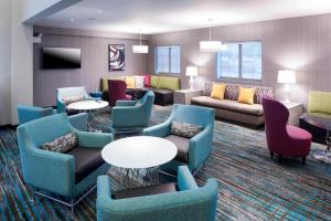 - un salon avec des canapés, des tables et des chaises dans l'établissement Residence Inn by Marriott Near Universal Orlando, à Orlando