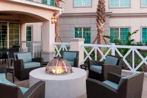 een vuurplaats op een patio met stoelen en tafels bij Residence Inn by Marriott Near Universal Orlando in Orlando