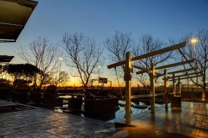 ein Holzkreuz auf einer Terrasse mit einem Sonnenuntergang im Hintergrund in der Unterkunft Protea Hotel by Marriott O R Tambo Airport in Kempton Park