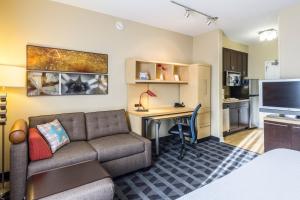 TownePlace Suites Dayton North في دايتون: غرفة معيشة مع أريكة ومكتب
