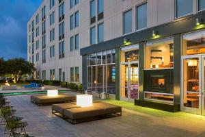 a building with benches in front of a building at Aloft San Antonio Airport in San Antonio