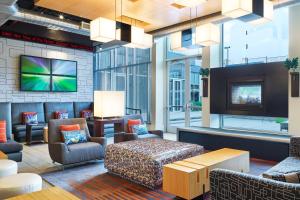 a hotel lobby with a tv and furniture at Aloft San Antonio Airport in San Antonio