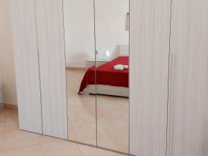 シラクーサにあるCasa Ortigiaのガラスのスライドドア、ベッド1台が備わる客室です。