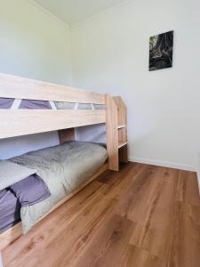 sypialnia z 2 łóżkami piętrowymi i drewnianą podłogą w obiekcie Three Pines House - Unique Tiny House with Views w mieście Mount Tamborine