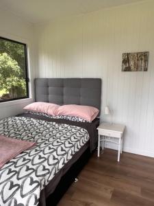 Three Pines House - Unique Tiny House with Views في جبل تامبورين: غرفة نوم بسرير كبير وطاولة