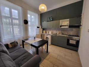 a living room with a couch and a table and a kitchen at Casa Nora in Budapest
