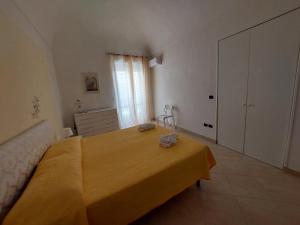 een slaapkamer met een bed met een gele deken erop bij Casa Ortigia in Siracusa