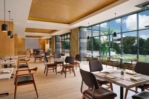 a restaurant with tables and chairs and large windows at Four Points by Sheraton Batam in Nagoya