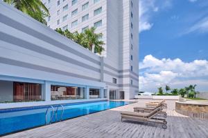 a hotel with a swimming pool next to a building at Four Points by Sheraton Batam in Nagoya