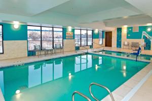a large pool with blue water in a building at TownePlace Suites by Marriott Anchorage Midtown in Anchorage