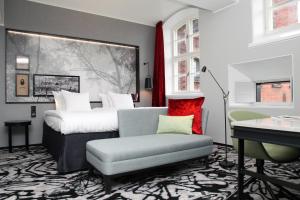 a bedroom with a bed and a couch and a chair at Home Hotel Katajanokka in Helsinki