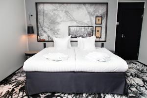 a bedroom with a large white bed with two towels on it at Home Hotel Katajanokka in Helsinki