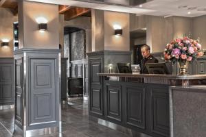 a man sitting at a bar in a hotel lobby at Clarion Collection Hotel Katajanokka in Helsinki