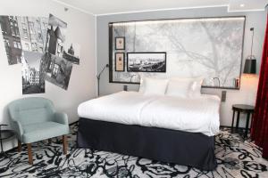 a bedroom with a large bed and a chair at Home Hotel Katajanokka in Helsinki