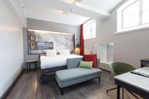 a bedroom with a bed and a chair and a table at Home Hotel Katajanokka in Helsinki