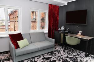 a living room with a couch and a desk at Home Hotel Katajanokka in Helsinki