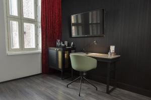 a desk with a chair and a mirror in a room at Home Hotel Katajanokka in Helsinki
