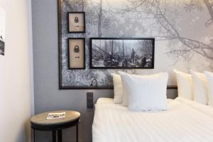 a bedroom with two white beds and a picture on the wall at Home Hotel Katajanokka in Helsinki