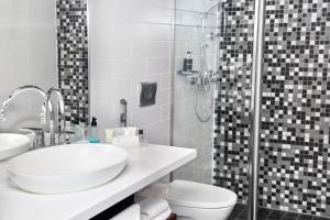 a bathroom with a toilet and a sink and a shower at Home Hotel Katajanokka in Helsinki