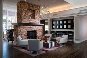 a living room with a brick fireplace and chairs at Residence Inn Melbourne in Melbourne