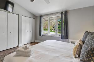 a bedroom with a large white bed and a window at YOUR New Luxury Lakeview Condo w Pool Access in Lake Geneva