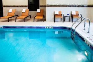 a pool in a hotel with chairs and a table at Courtyard by Marriott Walla Walla in Walla Walla