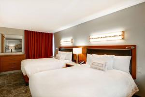 una camera d'albergo con due letti e uno specchio di SpringHill Suites Denver at Anschutz Medical Campus ad Aurora