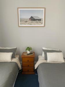 een slaapkamer met twee bedden en een tafel met een plant erop bij Bank Hotel Dungog in Dungog