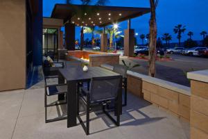 y un patio con mesa de comedor y sillas. en SpringHill Suites by Marriott Escondido Downtown, en Escondido