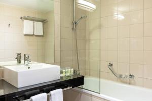 a bathroom with a sink and a shower at Courtyard by Marriott Paris Saint Denis in Saint-Denis