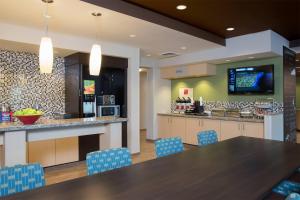 a kitchen with a long table and blue chairs at TownePlace Suites by Marriott Lexington South/Hamburg Place in Lexington