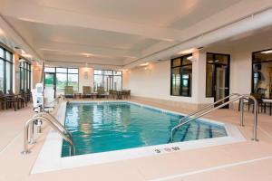 a swimming pool in a hotel with tables and chairs at TownePlace Suites by Marriott Lexington South/Hamburg Place in Lexington