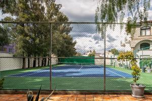 una pista de tenis vista a través de una valla de cadenas en Gated Community Home, Parking, Pool, Tennis court, en San Miguel de Allende